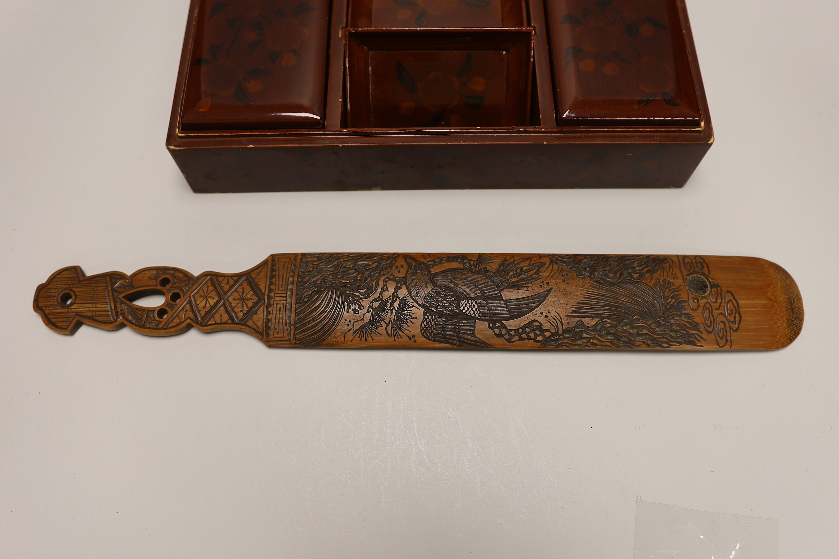 A Japanese lacquer games box, the cover having a central landscape painting together with a carved bamboo page turner, box 30 cm wide x 24 deep